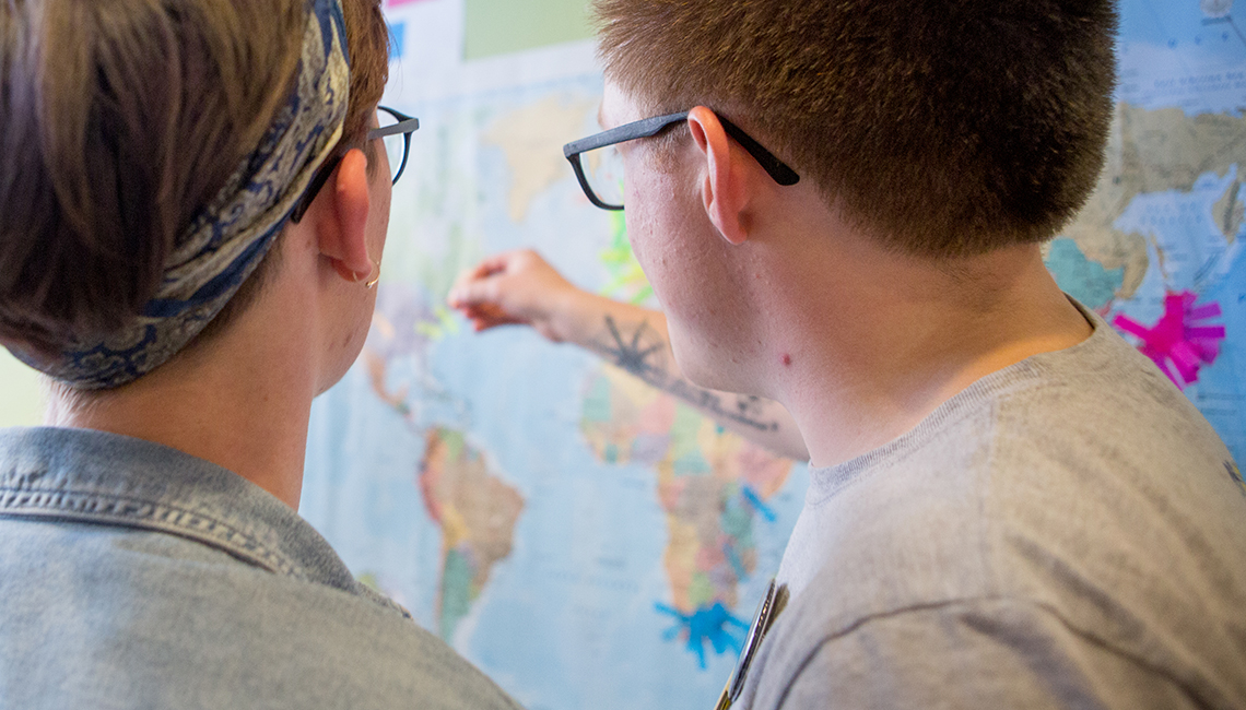 students pointing at map taken at International Jayhawk Festival